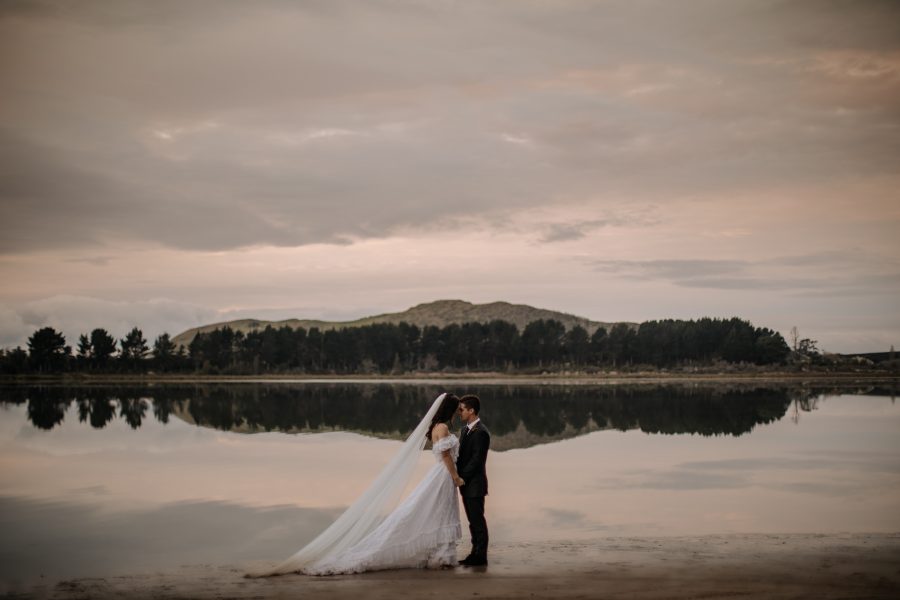 Elopement photo of couple with water reflection and island Tauranga harbour