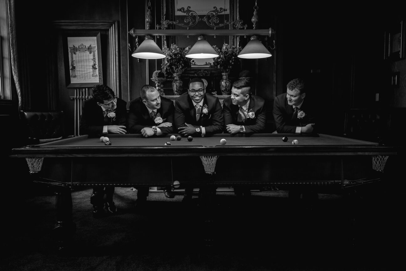 Groom with groomsmen on pool table