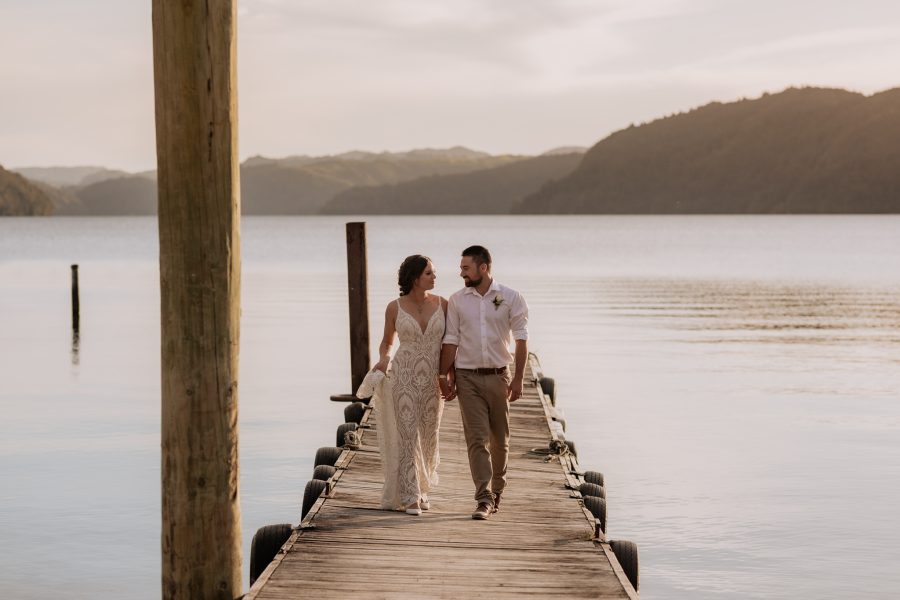 Bridal couple walking on pier at Lake Okataina