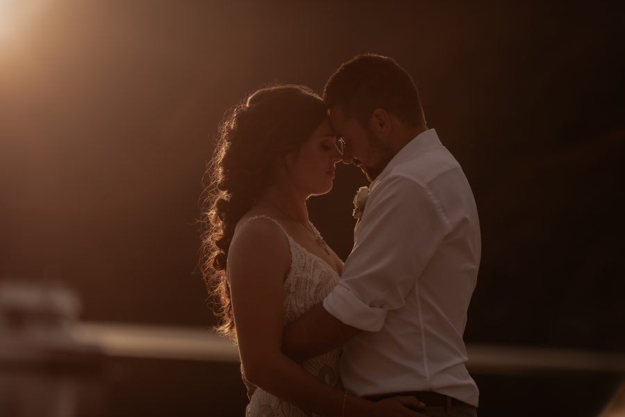 Light light photo taken of bride and groom as sunsets over Lake Okataina Rotorua NZ