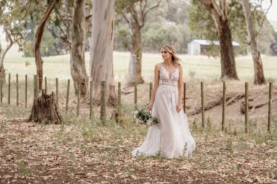 Waiterenui Farm wedding with bride standing under trees