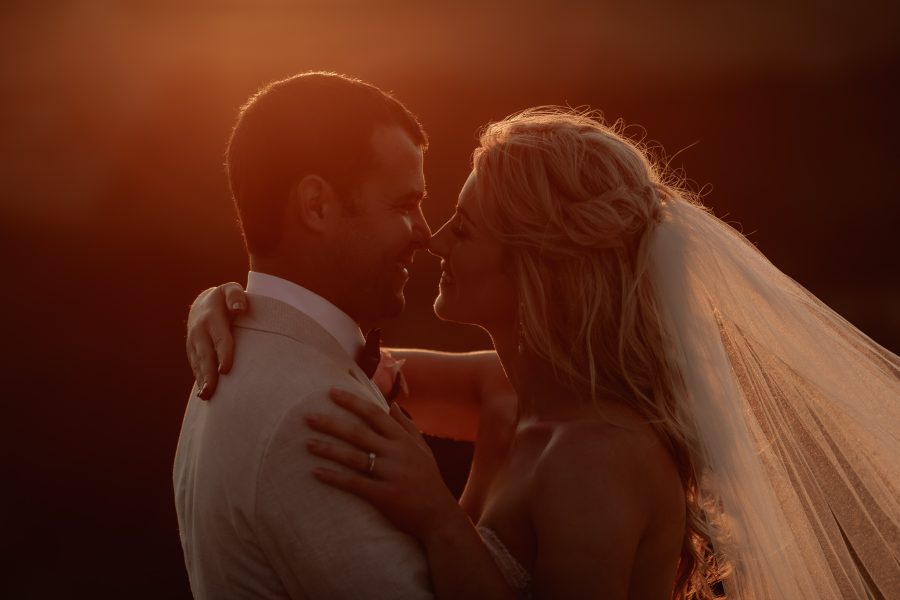 wedding couple kissing at golden hour in the tauranga  hills