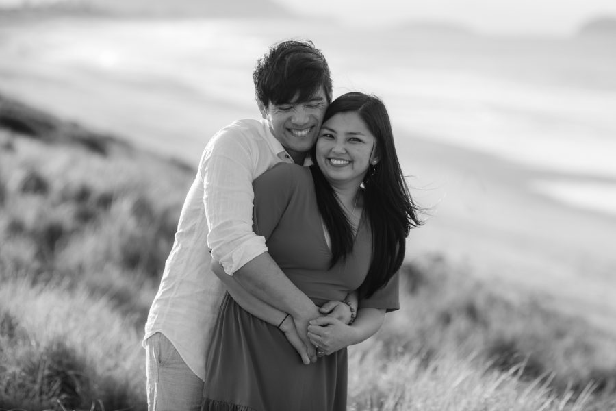 giggling photo of engaged couple at beach