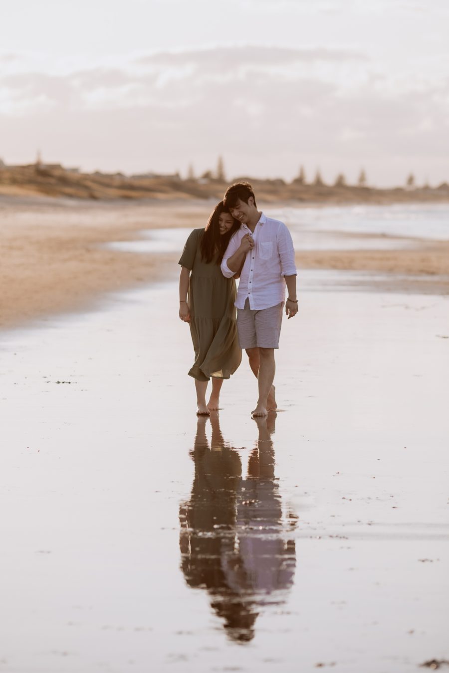 candid happy couple on beach water reflections