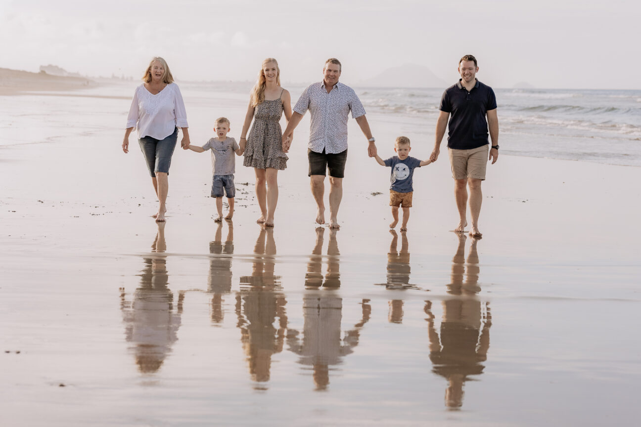 family photo walking on papamoa beach reflection in sand