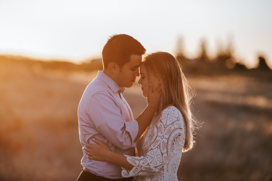 Natural moment between bride and groom at golden hour on beach at Whakatane wedding celebration