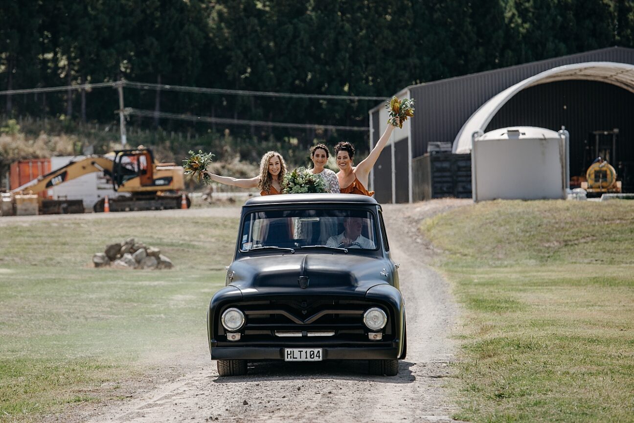 Bride and bridesmaids arrive in vintage truck