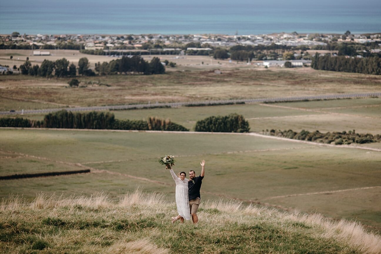 Happy bride and groom waving