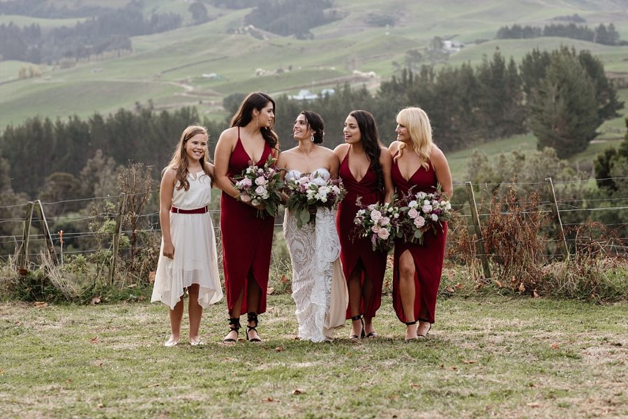 bride walking with bridesmaids on the hills above Tauranga