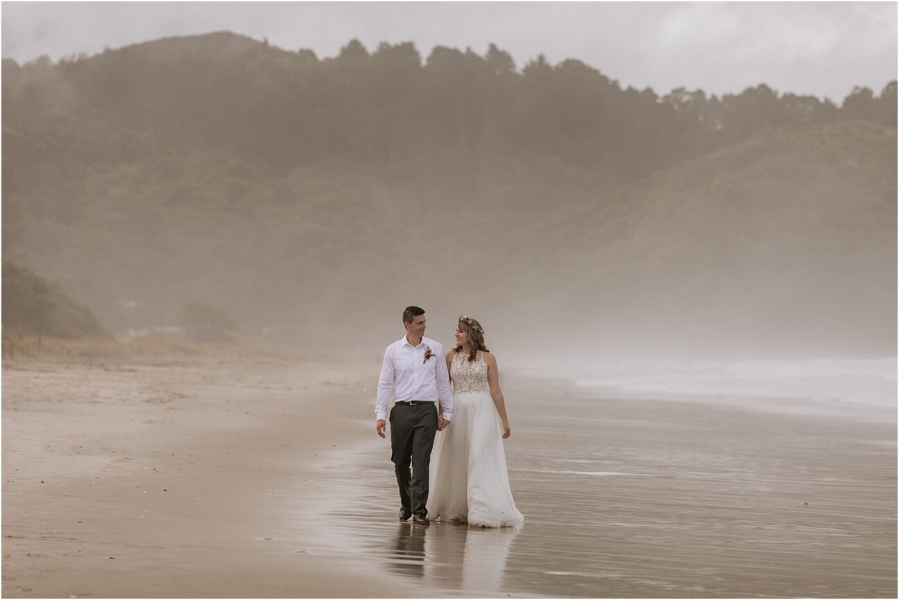 Bride and groom Holly and Patrick walking the beach