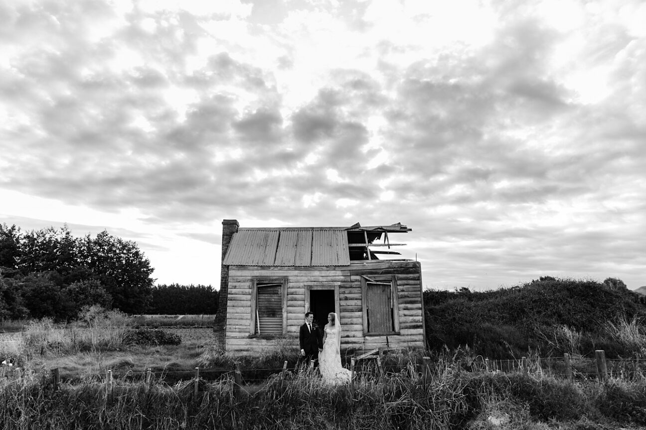 Old black and white house with bride and groom