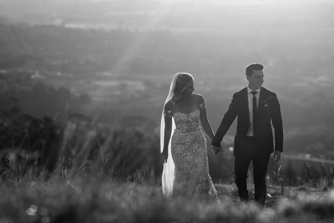 Bride and groom walking laughing up Te Mata Peak