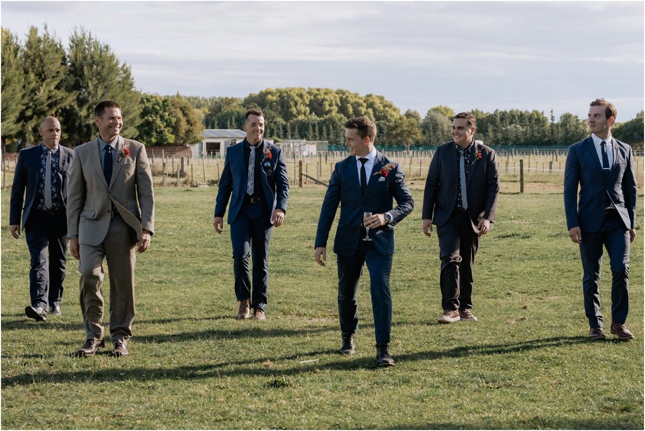 Grooms men all walking across field