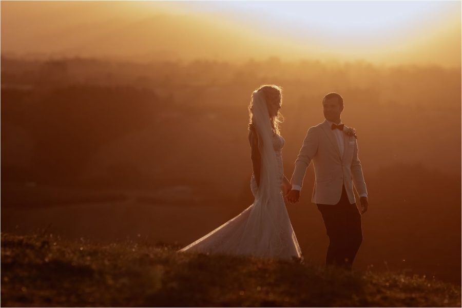 Bride and groom walking at sunset