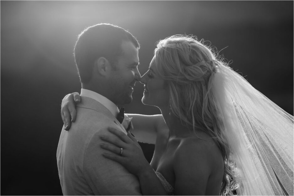 Black and white kissing photo as sunsets