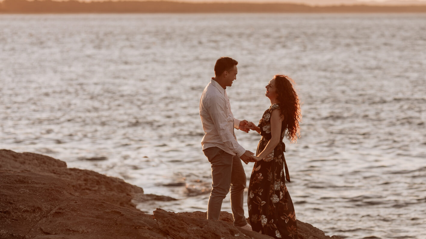 Couple dancing on rocks at Mount Maunganui