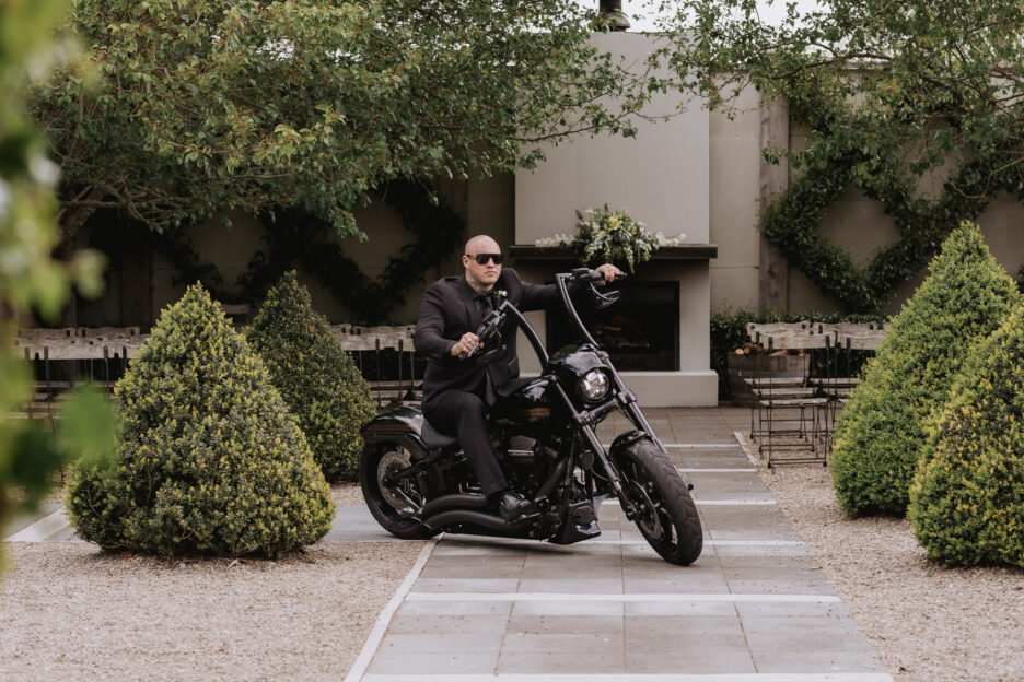 Groom riding Harley Davidson at Tauranga Wedding