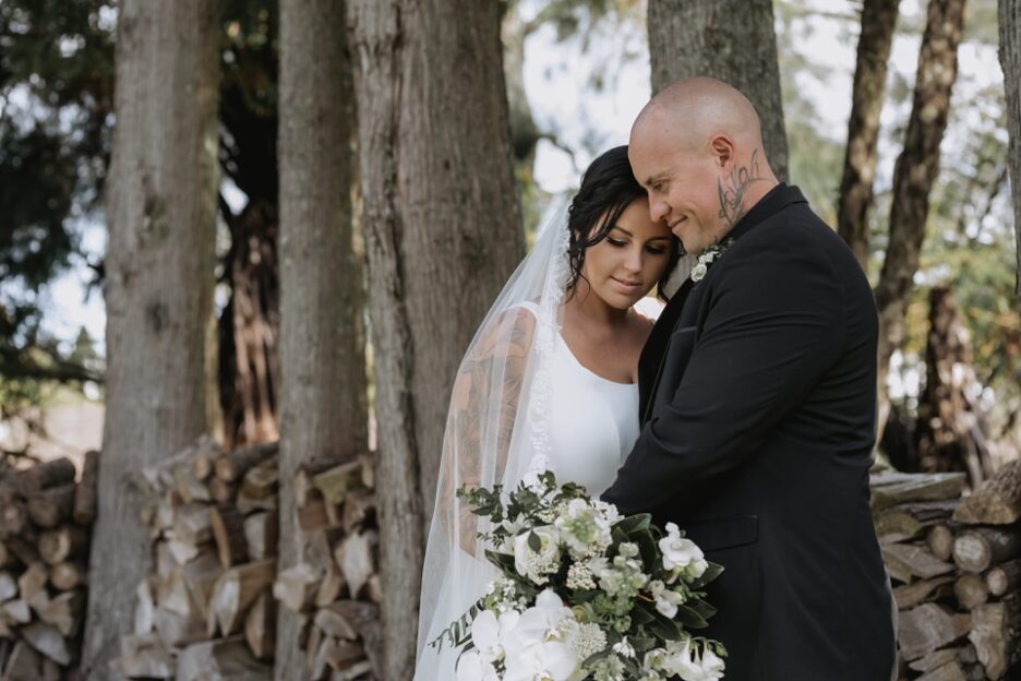 Bride and groom taking a moment by the wood pile at Ataahua New Zealand Wedding venue