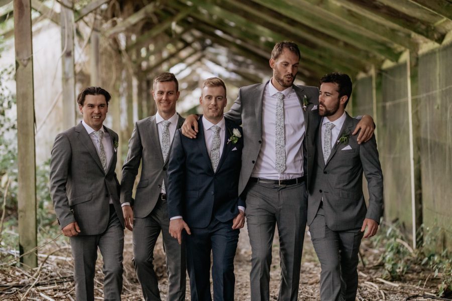 Groom with his Boys in grey suits walking in old glass house