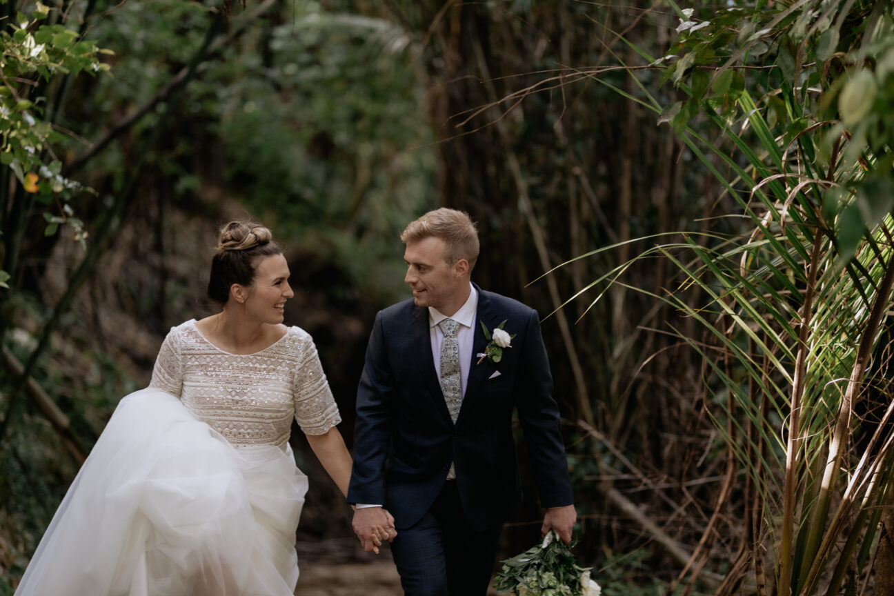 Wedding photo of bridal couple walking happily uphill