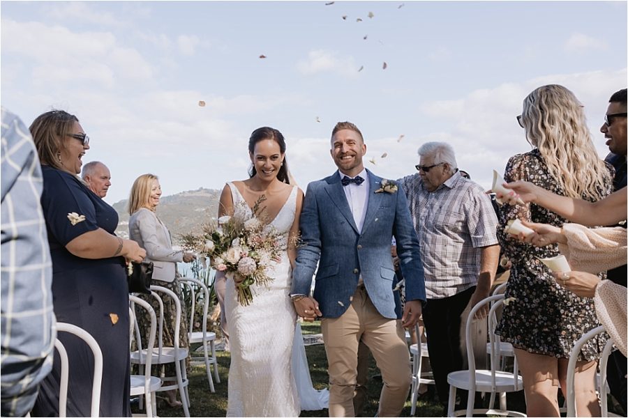 Happy aisle walk at Orua Beach house wedding