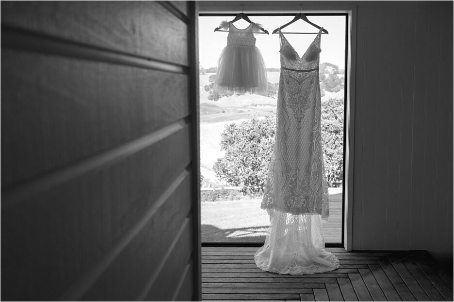 Brides dress and flower girls dress hanging at Orua Beach house
