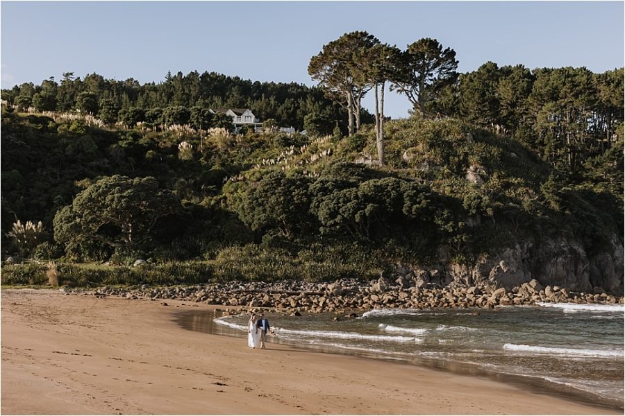 Bride and groom walking hot water beach Orua Beach house