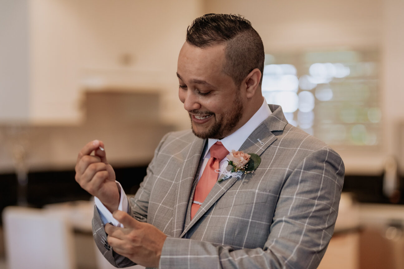 Groom putting on cufflinks