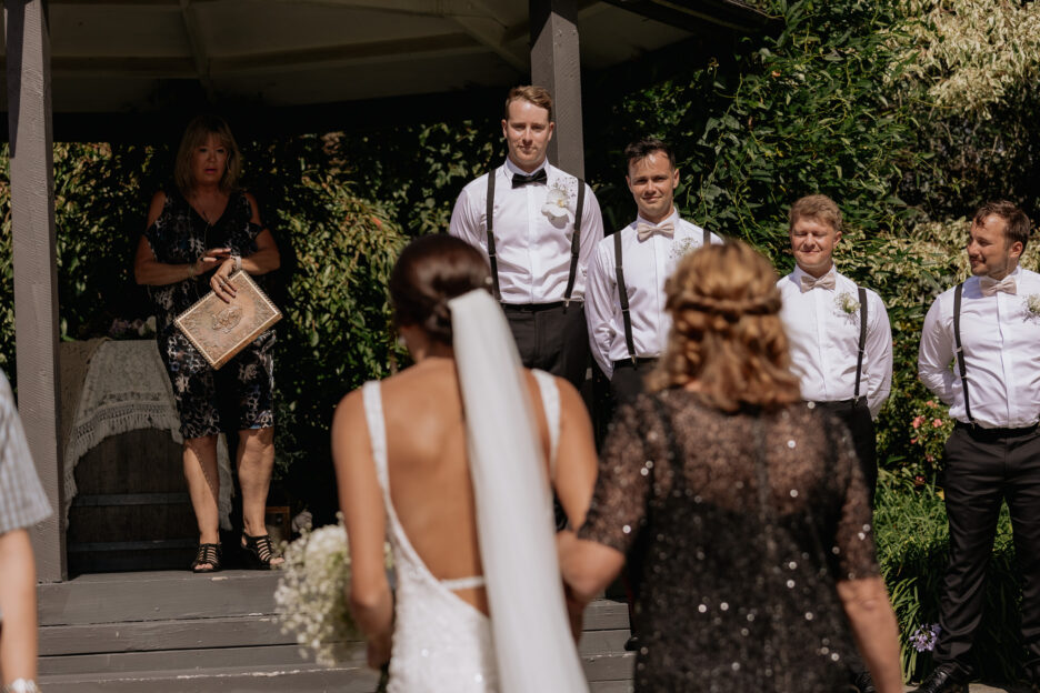 Groom watches bride walk towards him