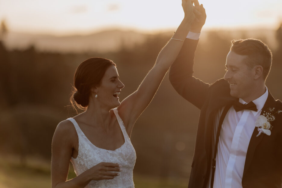 Bride and groom dancing in the field