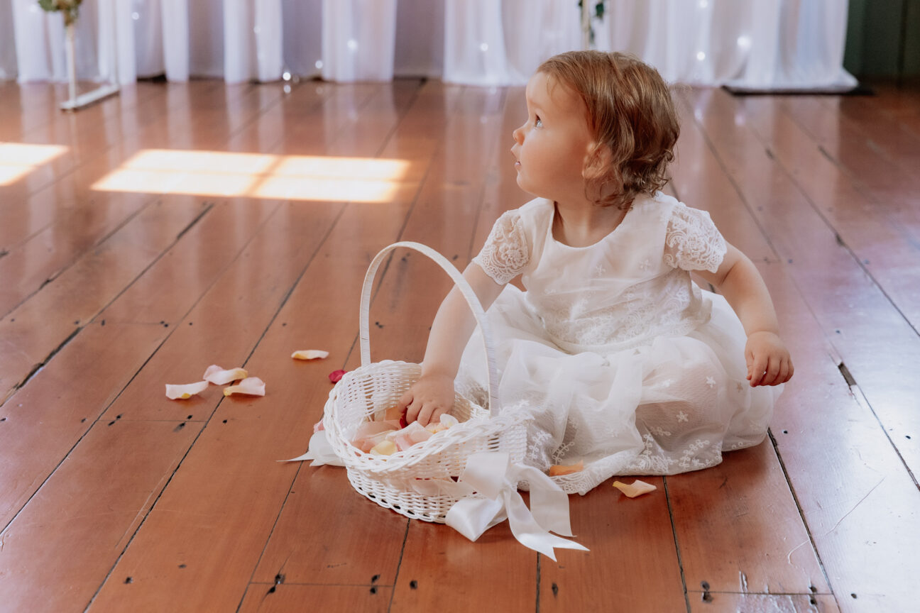 Flower girl with hand in basket of petals