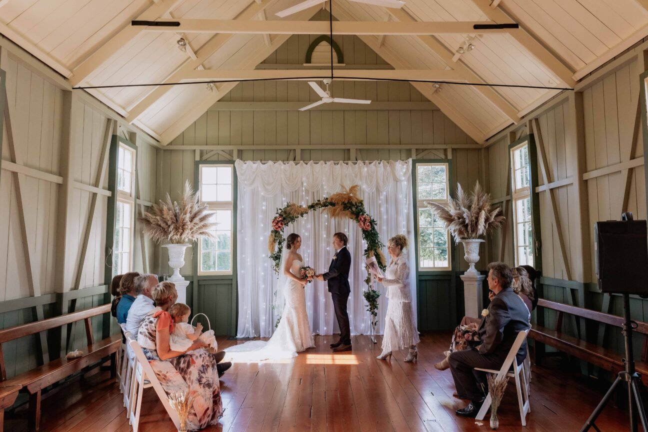 Wedding ceremony in progress under arch