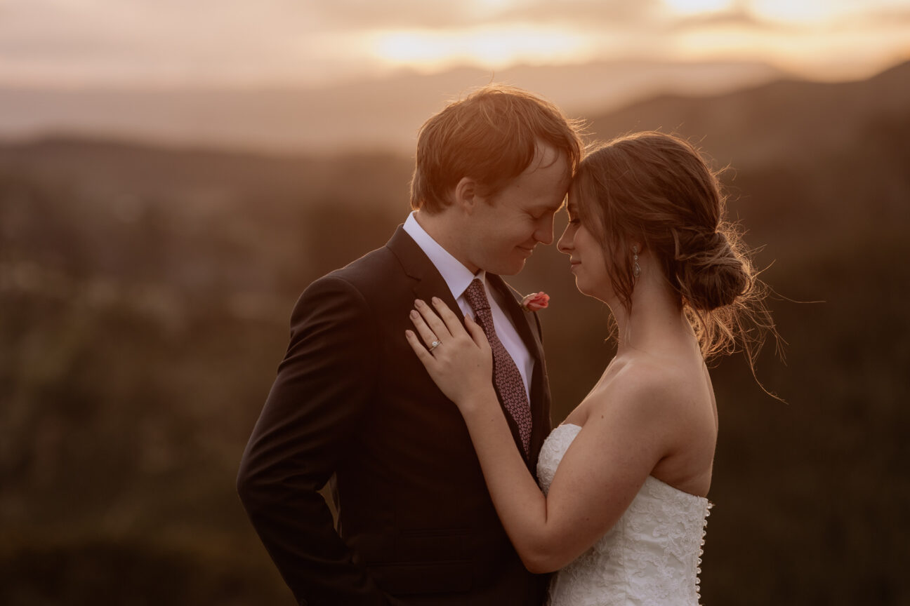 Cuddling bridal couple in golden light