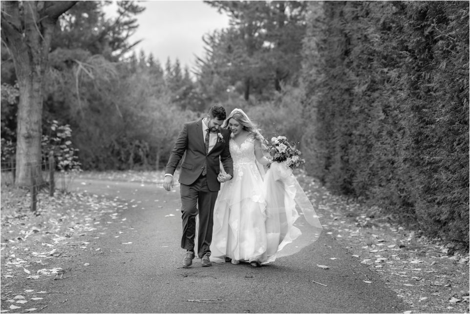 Moment between bride and groom walking on country road at Makoura Lodge