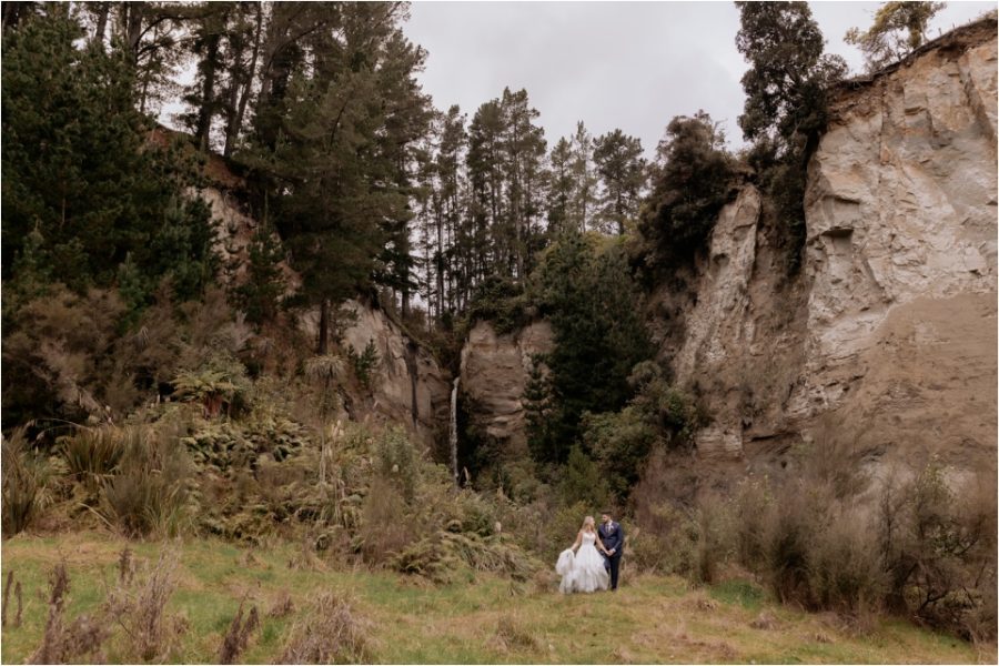 Bridal portraits in front of waterfall at Makoura Lodge