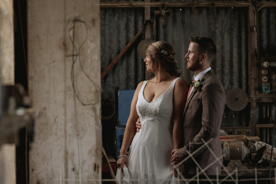 wedding portrait of bride and groom in door way of rustic shed