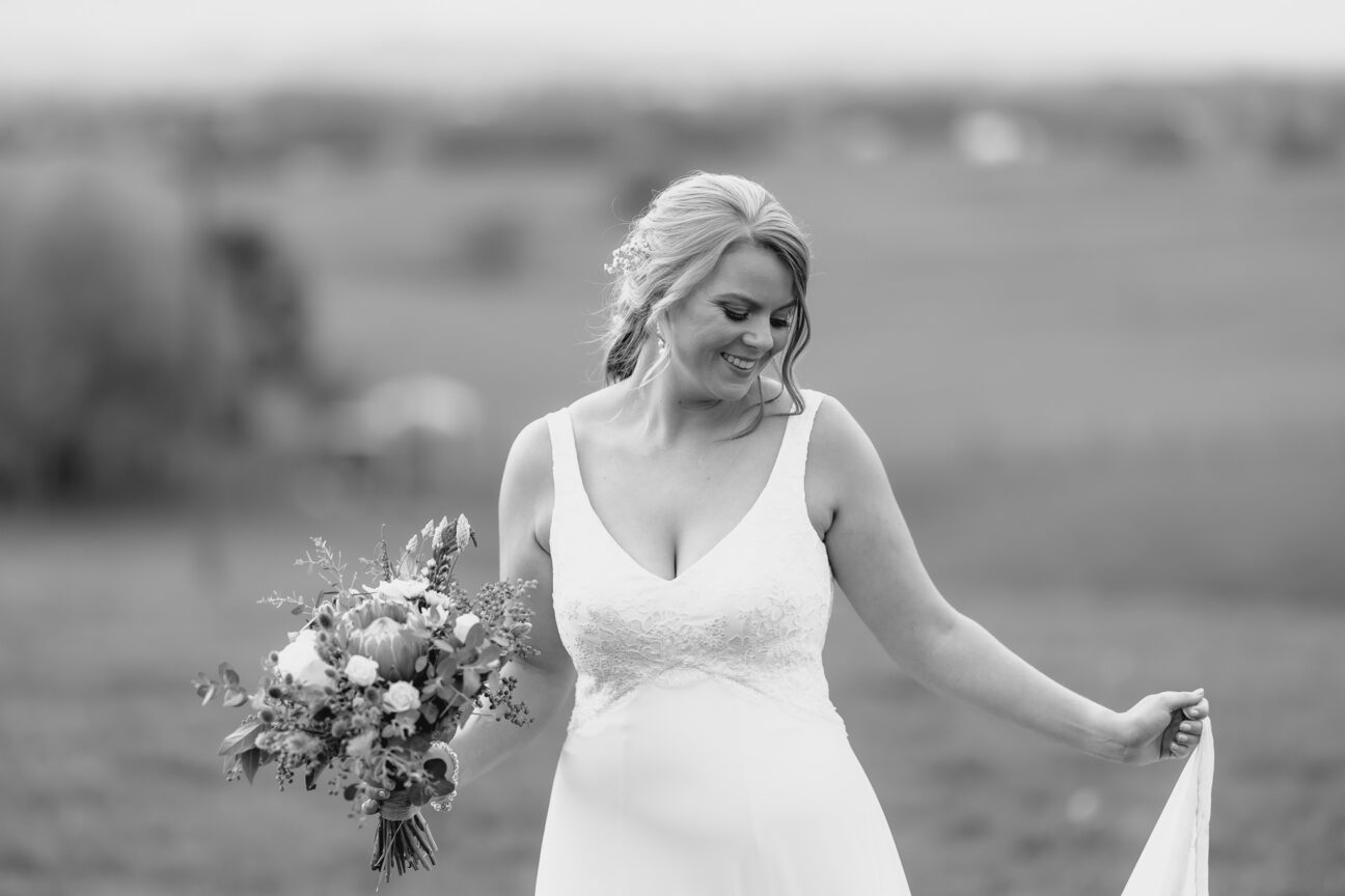 Bride walking naturally looking down at dress smiling