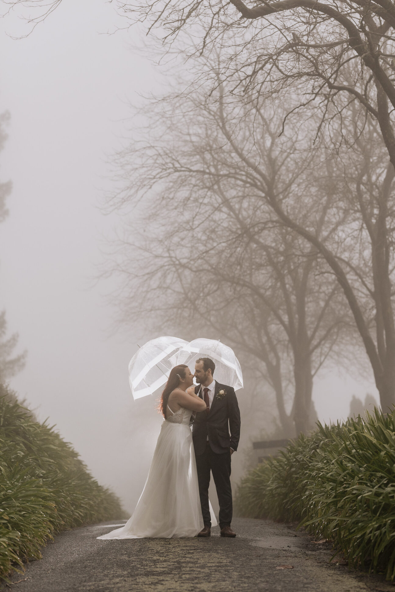 wedding photos in the rain bride and groom looking at eachother