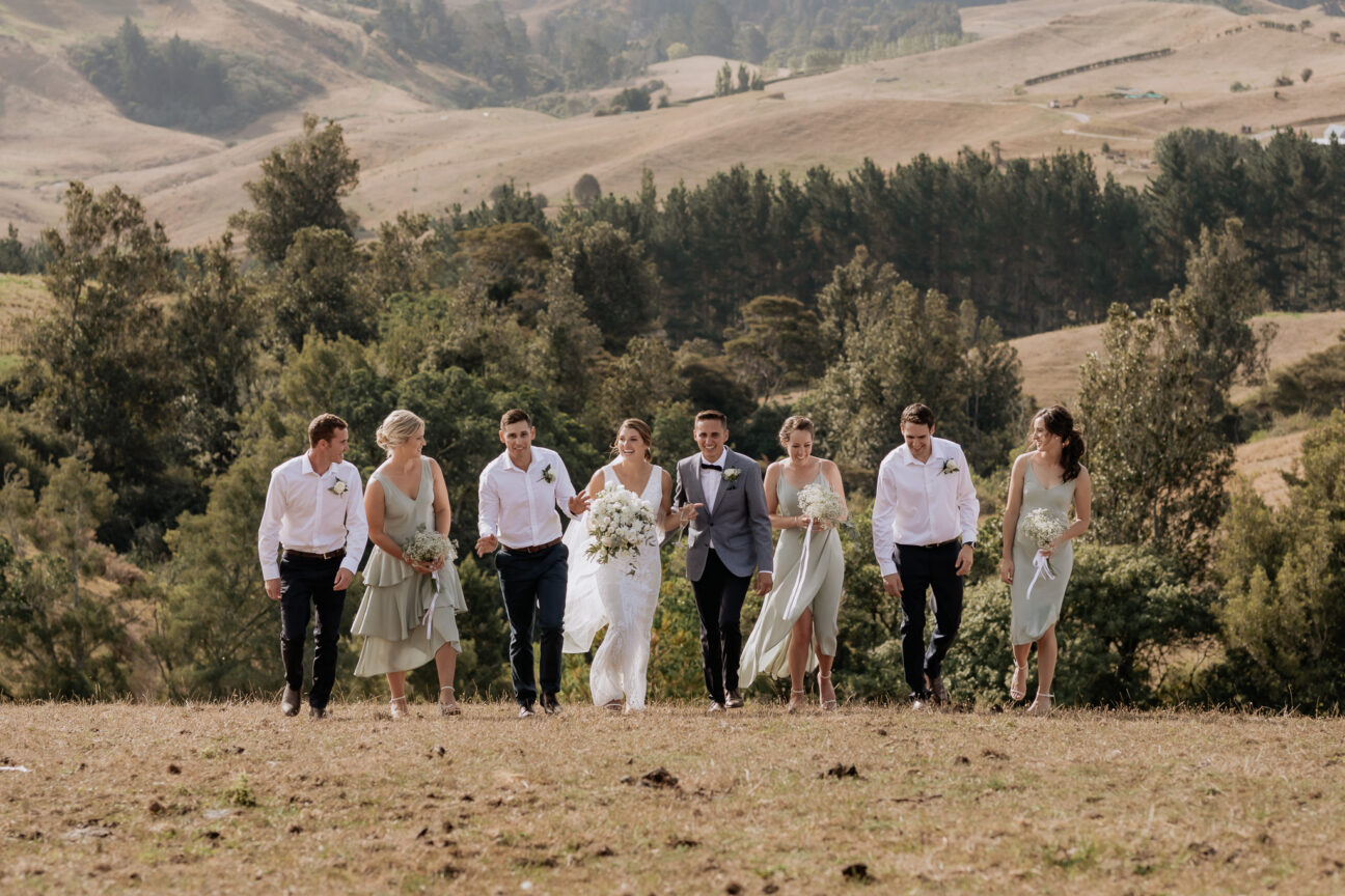 Tauranga bridal party walking in the summer hills with green pistachio bridesmaids