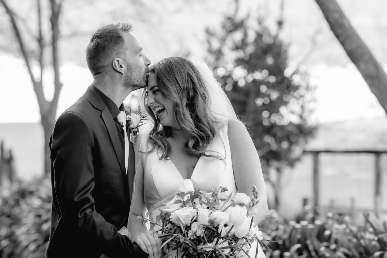 groom kisses bride on forehead