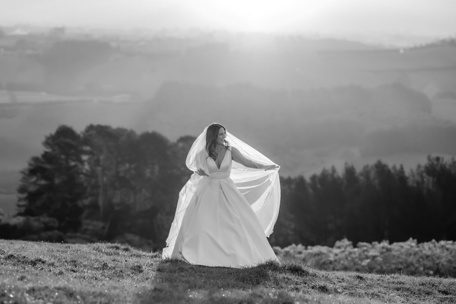 bride holds windy veil