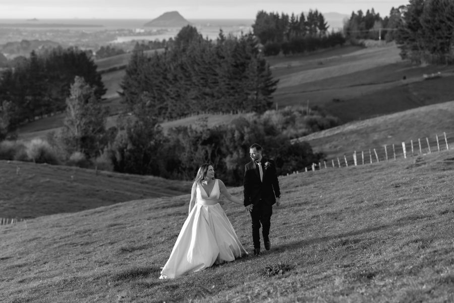 views above tauranga wedding bride and groom walking along hills