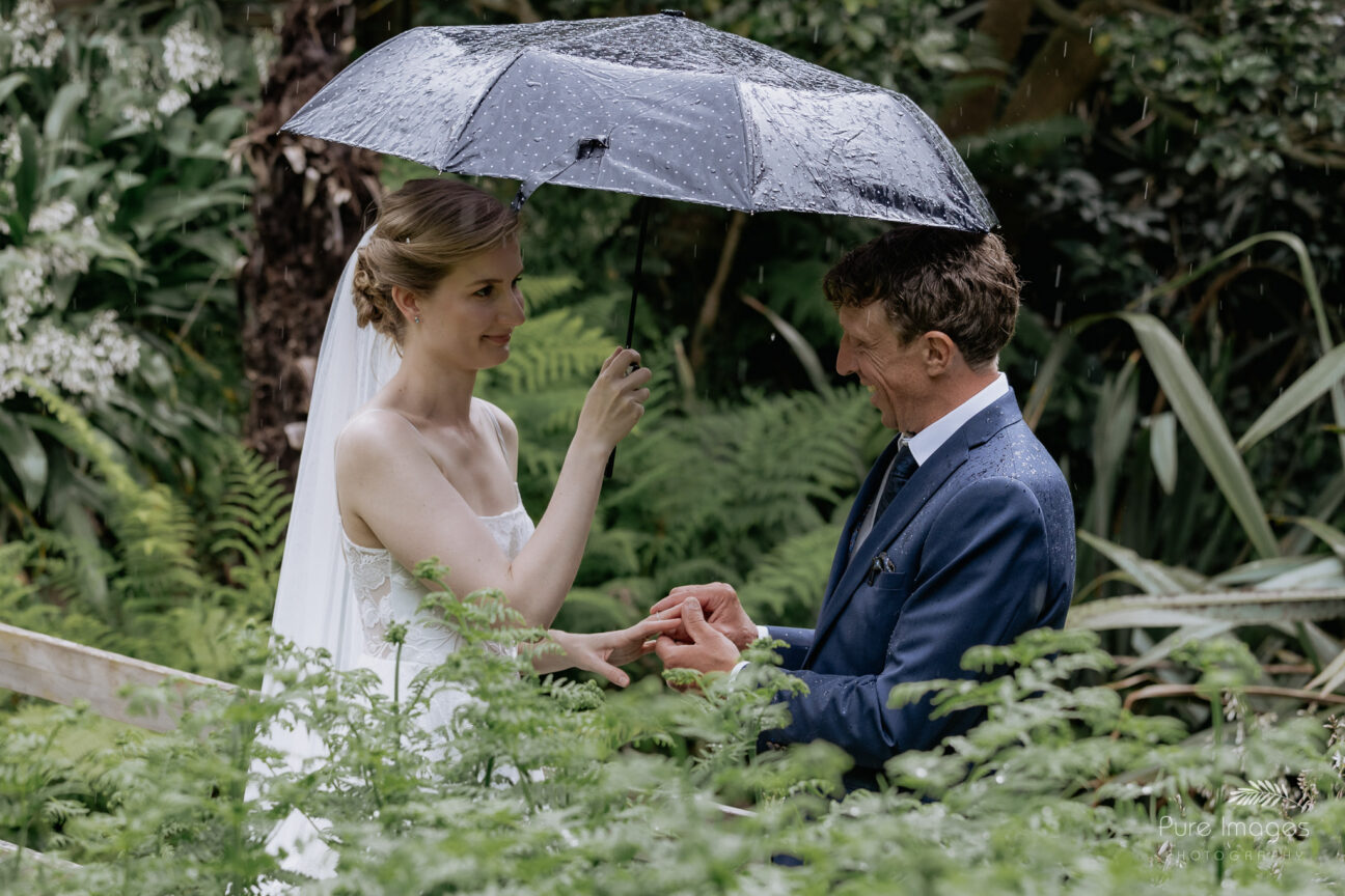 Rings going on mid ceremony in the rain