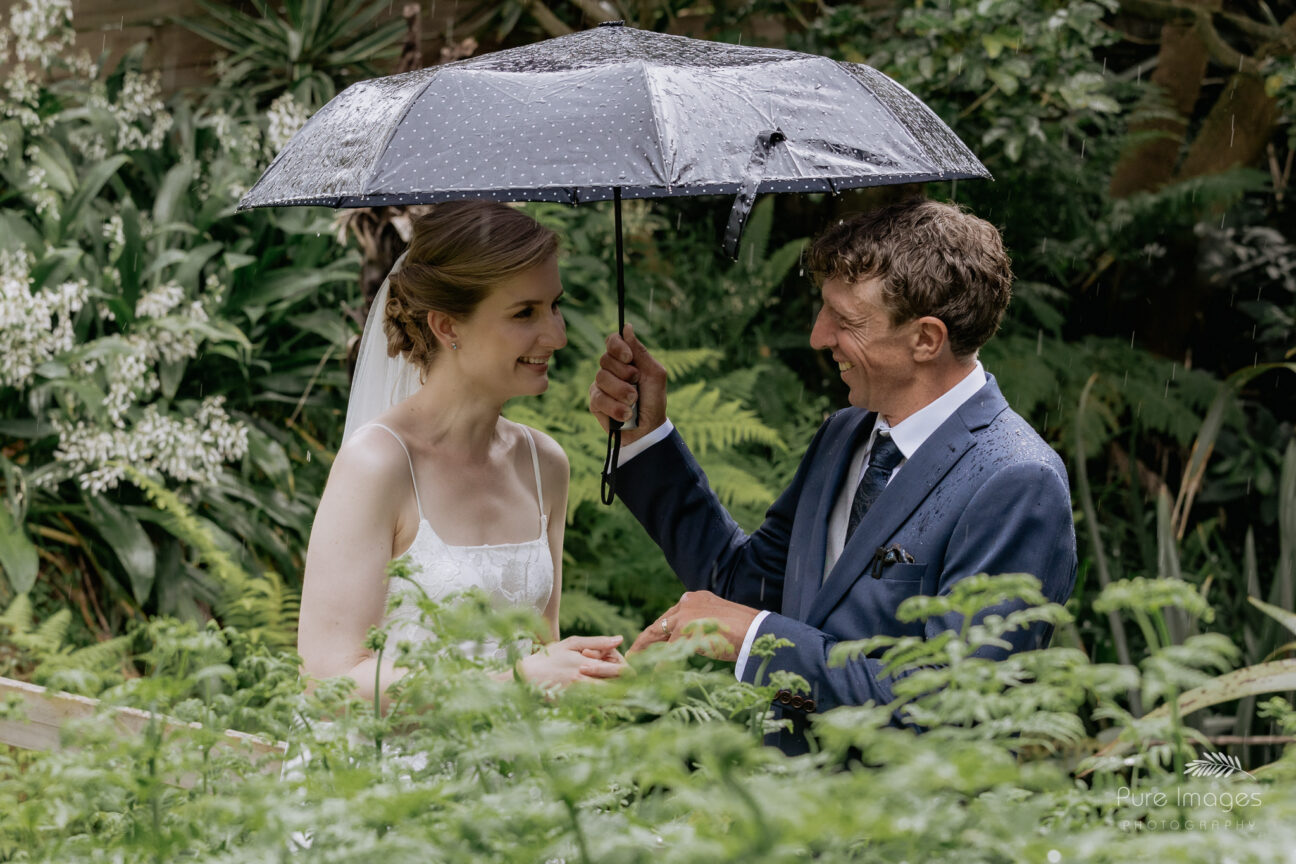 wedding ceremony in the rain smiling bride and groom