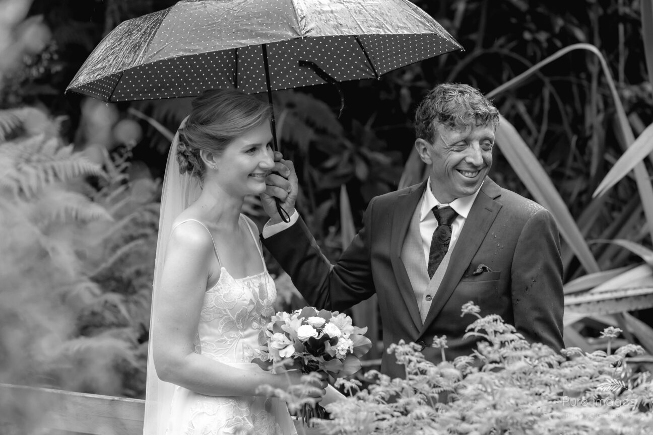 happy smiling Bride and groom getting married in the rain
