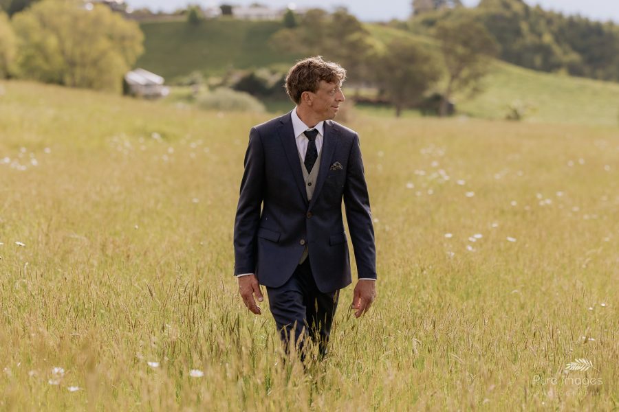 groom walking in field