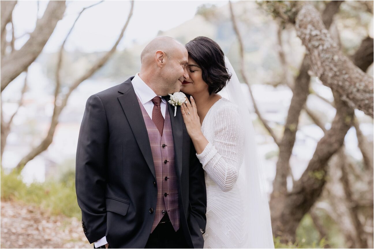 Bride snuggling into shoulder of groom