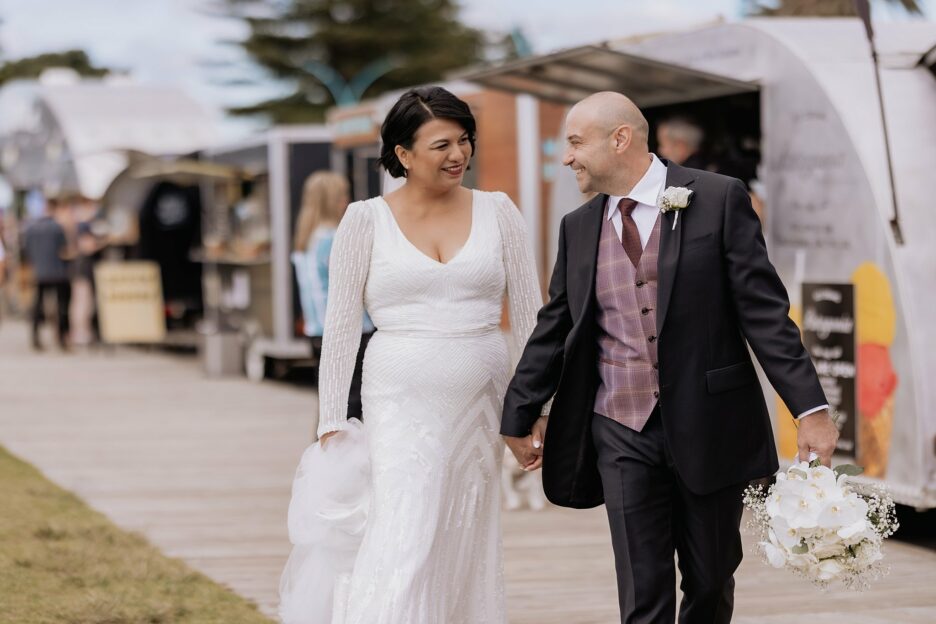Couple walking along food trucks on their wedding day in New Zealand