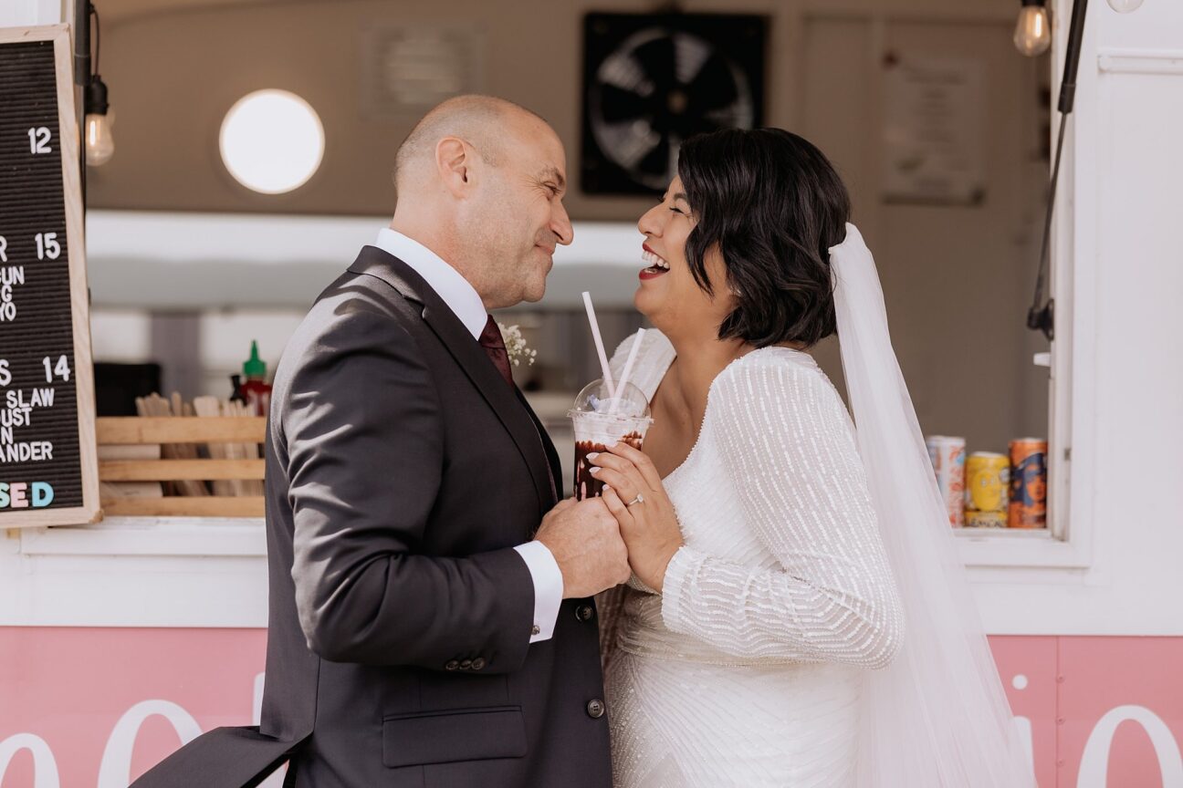 Wedding couple laughing over sharing icecream sundae