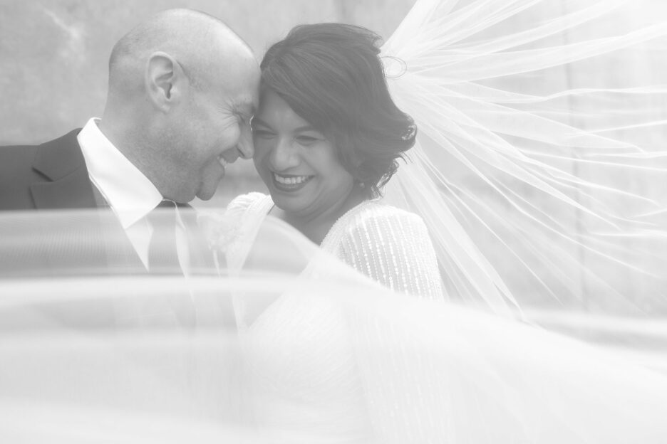 Bride and groom behind veil